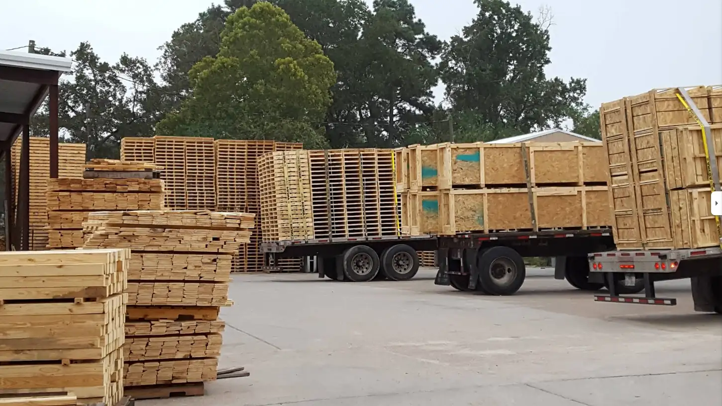 Stacks of pallets and crates on flat-bed trucks